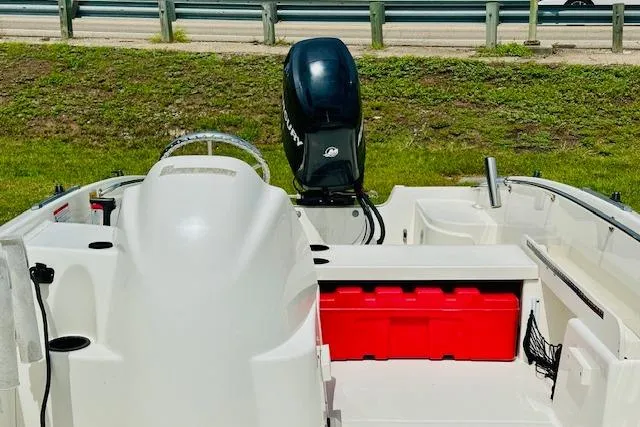 Slide: The Image of 2011 Boston Whaler 170 Super Sport boat with outboard motor and red storage box. - 12