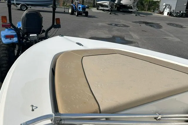 Slide: The Image of 2016 Scout 177 Sport boat with beige seating, parked near blue tractor. - 5