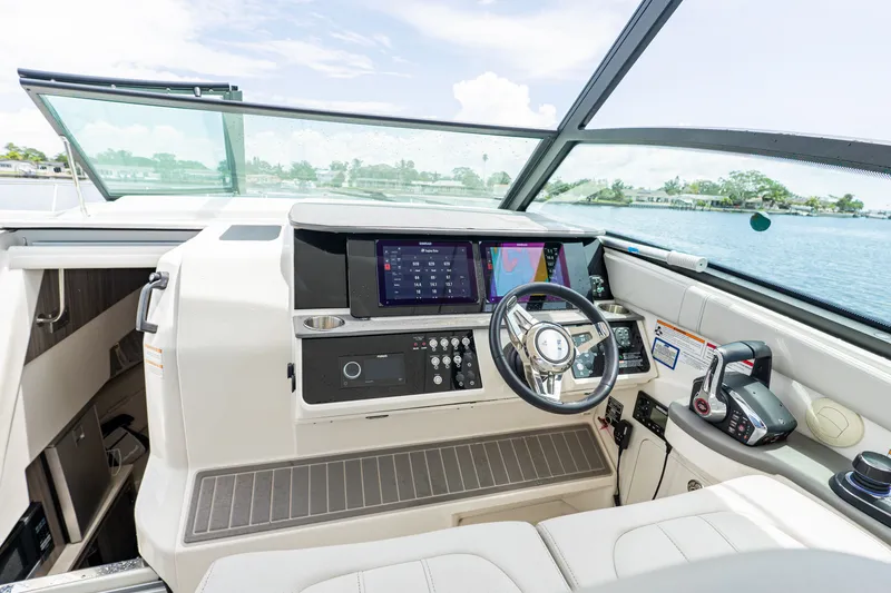 Slide: The Image of The cockpit of the 2024 Sea Ray Sundancer 320 Outboard features modern instruments and sleek design. - 19