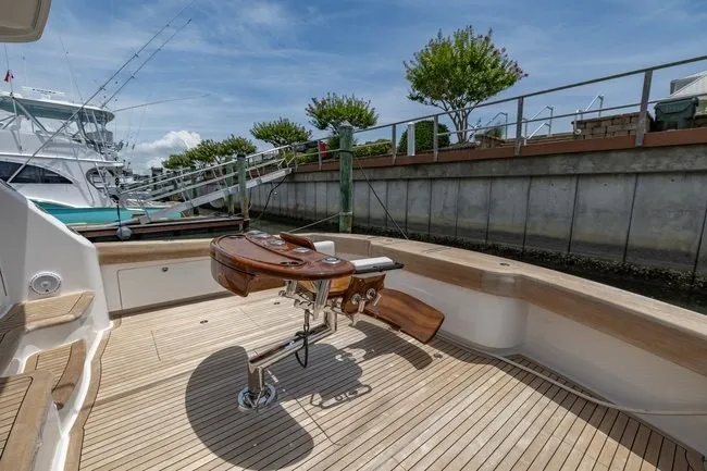 Slide: The Image of 2025 Viking 58 Convertible yacht with teak deck and fishing chair at marina. - 27