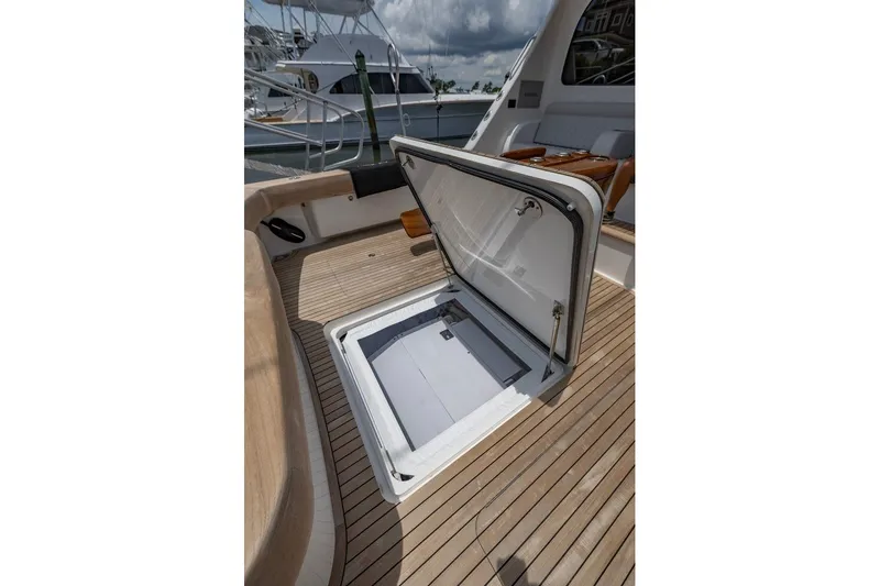 Slide: The Image of Open hatch on 2025 Viking 58 Convertible yacht deck, showcasing storage space. - 30