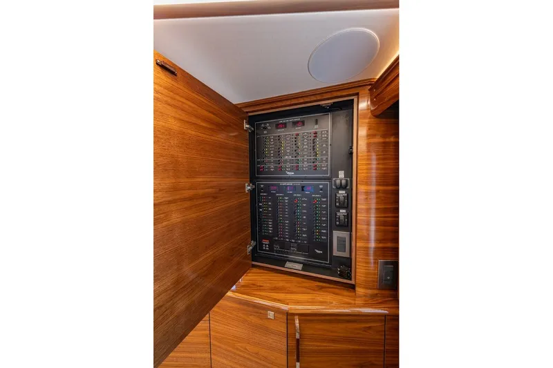 Slide: The Image of Electrical panel inside 2025 Viking 58 Convertible yacht, featuring sleek wooden cabinetry. - 43