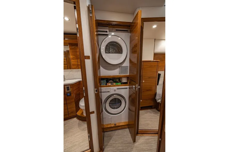 Slide: The Image of Laundry area with stacked washer and dryer in 2025 Viking 58 Convertible yacht. - 52