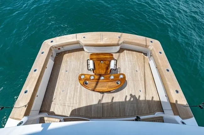 Slide: The Image of 2025 Viking 58 Convertible yacht deck with fishing chair, surrounded by blue ocean. - 26