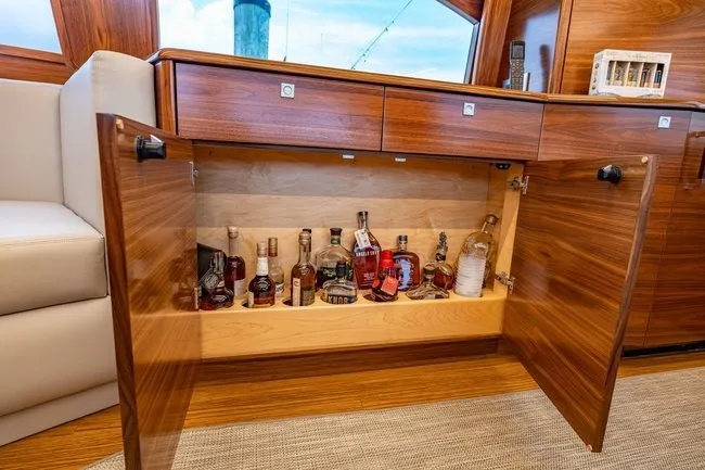 Slide: The Image of Luxurious wooden cabinet with liquor bottles inside a 2025 Viking 58 Convertible yacht. - 44