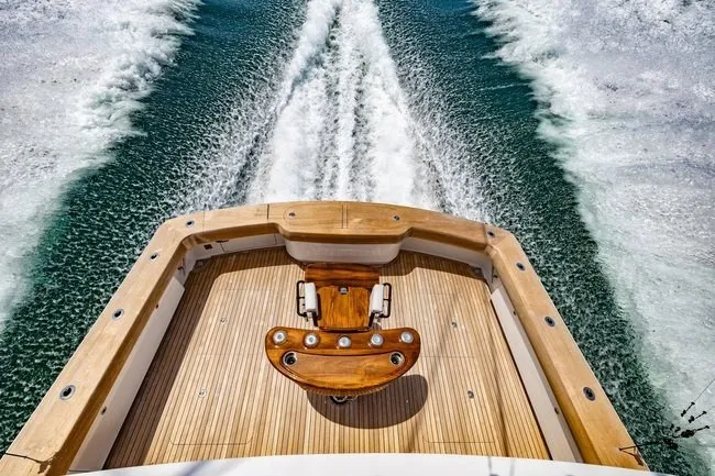 Slide: The Image of 2025 Viking 58 Convertible yacht cruising, showcasing elegant teak deck and powerful wake. - 4