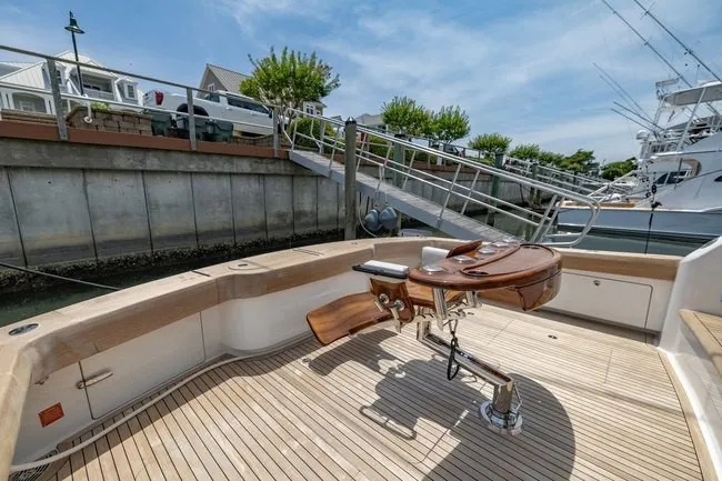 Slide: The Image of 2025 Viking 58 Convertible yacht with teak deck and fishing chair in marina. - 28