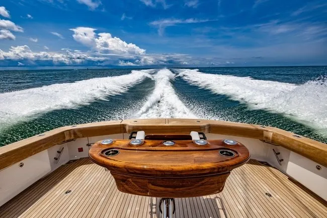 Slide: The Image of 2025 Viking 58 Convertible yacht cruising on open sea under clear blue skies. - 15