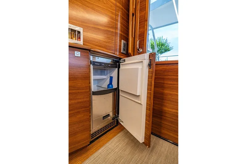 Slide: The Image of Luxury interior of 2025 Viking 58 Convertible yacht with open mini fridge. - 46