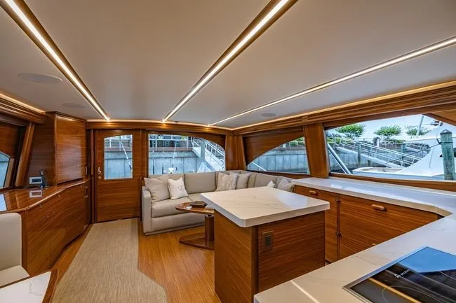 Slide: The Image of Luxurious interior of 2025 Viking 58 Convertible yacht with modern wood finishes and elegant seating. - 38