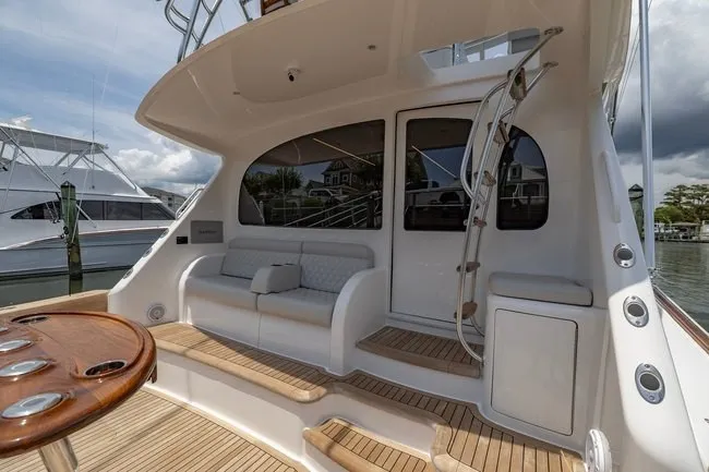 Slide: The Image of 2025 Viking 58 Convertible yacht with elegant seating and sleek design in a marina setting. - 29
