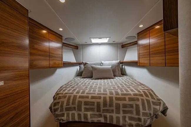 Slide: The Image of Luxurious bedroom interior of 2025 Viking 58 Convertible yacht with wood cabinetry and skylight. - 48