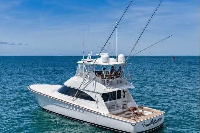 Slide: The Image of The 2025 Viking 58 Convertible is a sleek sportfishing boat on open water with a spacious deck. - 6