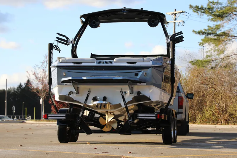 Slide: The Image of 2026 Supreme S220 boat on trailer, rear view, parked outdoors. - 12