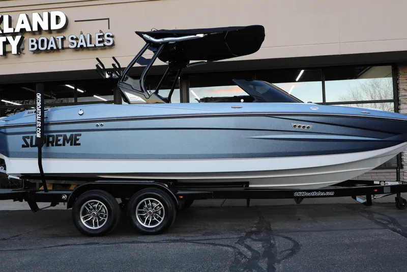 Slide: The Image of 2026 Supreme S220 boat on trailer at dealership, featuring sleek design and modern features. - 2