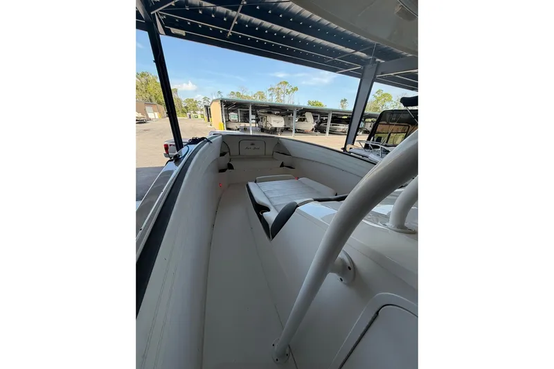Slide: The Image of 2013 Nor-Tech 340 Sport boat interior, showcasing seating and deck under a canopy. - 13