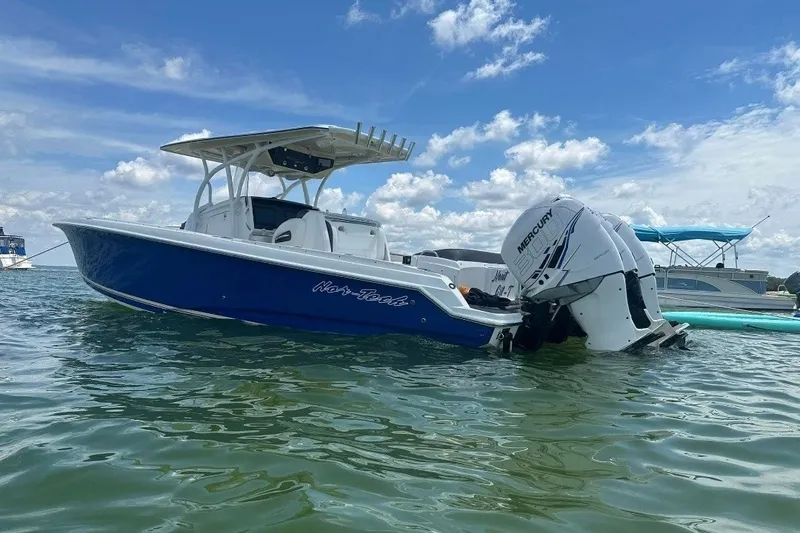 Slide: The Image of 2013 Nor-Tech 340 Sport boat with Mercury engines on calm water under blue sky. - 11