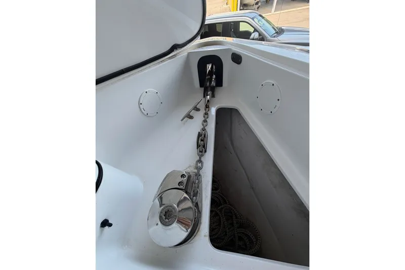 Slide: The Image of Anchor chain compartment of 2013 Nor-Tech 340 Sport boat, featuring a polished winch. - 24