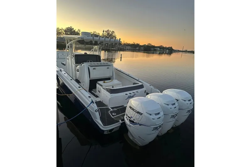 Slide: The Image of 2013 Nor-Tech 340 Sport boat with triple Mercury engines at sunset on calm water. - 17
