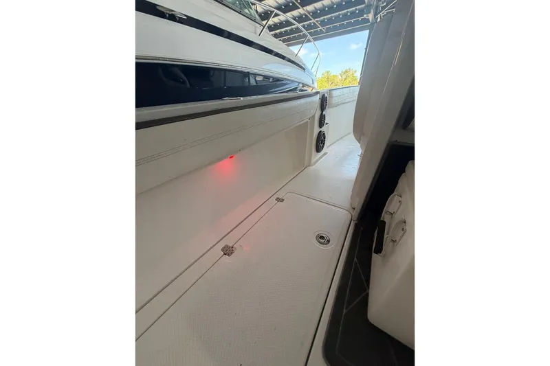 Slide: The Image of 2013 Nor-Tech 340 Sport boat interior with sleek white deck and ambient lighting. - 16