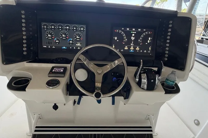 Slide: The Image of Dashboard of a 2013 Nor-Tech 340 Sport boat with dual displays and steering wheel. - 4