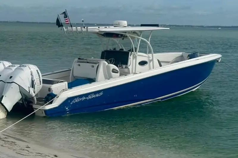 The Image of 2013 Nor-Tech 340 Sport boat anchored on a sandy beach with clear water. - 1