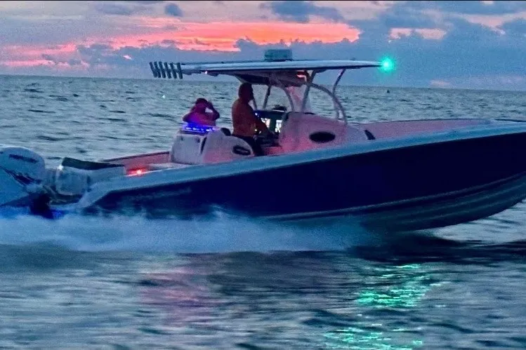Slide: The Image of 2013 Nor-Tech 340 Sport boat cruising at sunset on the ocean. - 2