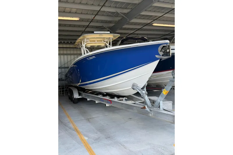 Slide: The Image of 2013 Nor-Tech 340 Sport boat in storage, blue hull, on trailer. - 3