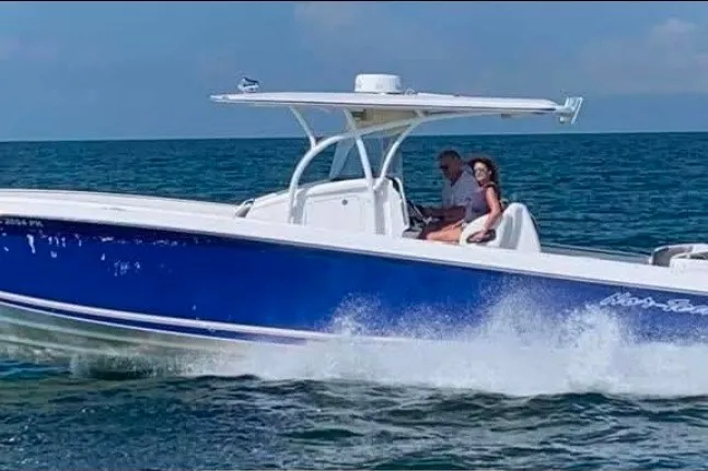 Slide: The Image of 2013 Nor-Tech 340 Sport boat cruising on open water with two passengers. - 0