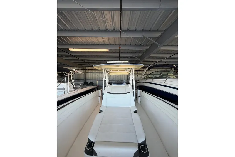 Slide: The Image of 2013 Nor-Tech 340 Sport boat in storage, showcasing sleek design and spacious deck. - 23