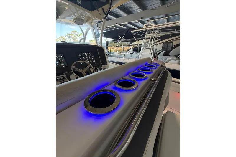 Slide: The Image of 2013 Nor-Tech 340 Sport boat console with illuminated cup holders and steering wheel. - 19