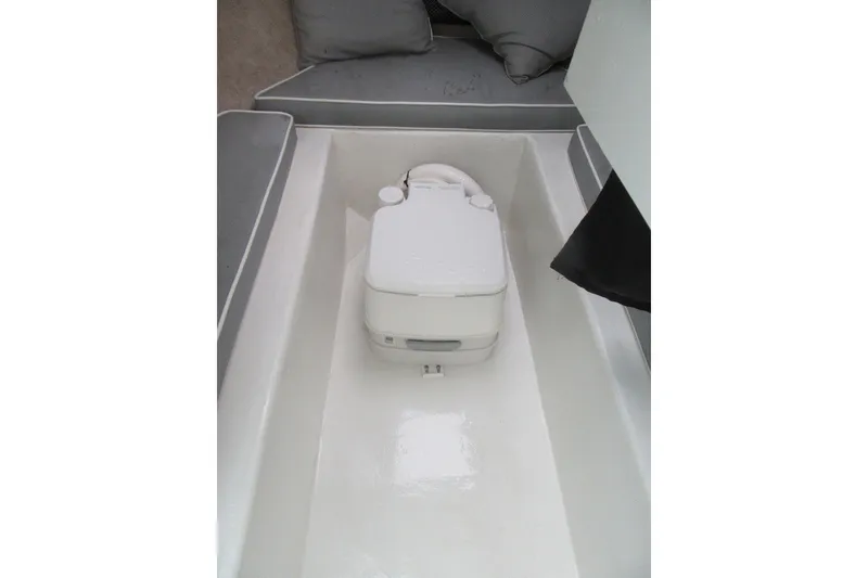 Slide: The Image of 2016 Parker 2120 Sport Cabin interior with portable toilet and cushioned seating. - 28