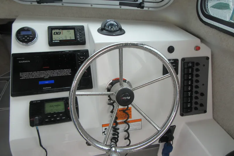 Slide: The Image of Steering wheel and controls of 2016 Parker 2120 Sport Cabin boat. - 24