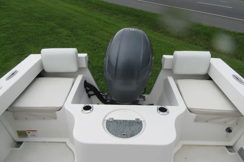 Slide: The Image of 2016 Parker 2120 Sport Cabin boat with outboard motor and cushioned seating. - 20