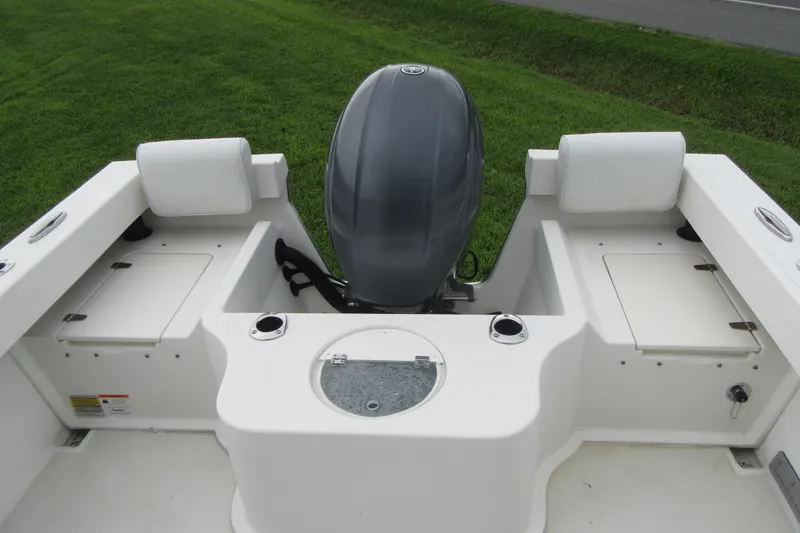Slide: The Image of 2016 Parker 2120 Sport Cabin boat with outboard motor and storage compartments. - 13