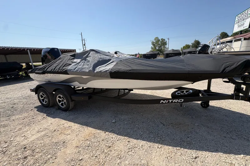 Slide: The Image of 2027 Nitro Z20 XL Pro boat covered on a trailer in a gravel lot. - 16