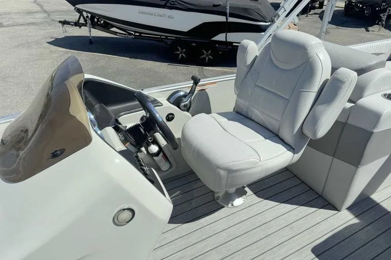 Slide: The Image of 2019 Avalon Catalina Rear Lounge boat interior with captain's chair and steering console. - 7