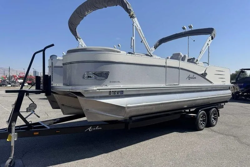 Slide: The Image of 2019 Avalon Catalina Rear Lounge 25' pontoon boat on trailer, parked outdoors. - 6