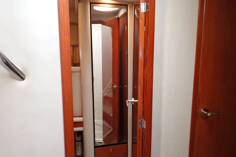 Slide: The Image of Interior view of 1998 Sea Ray 480 Sedan Bridge with wooden doors and mirror. - 141