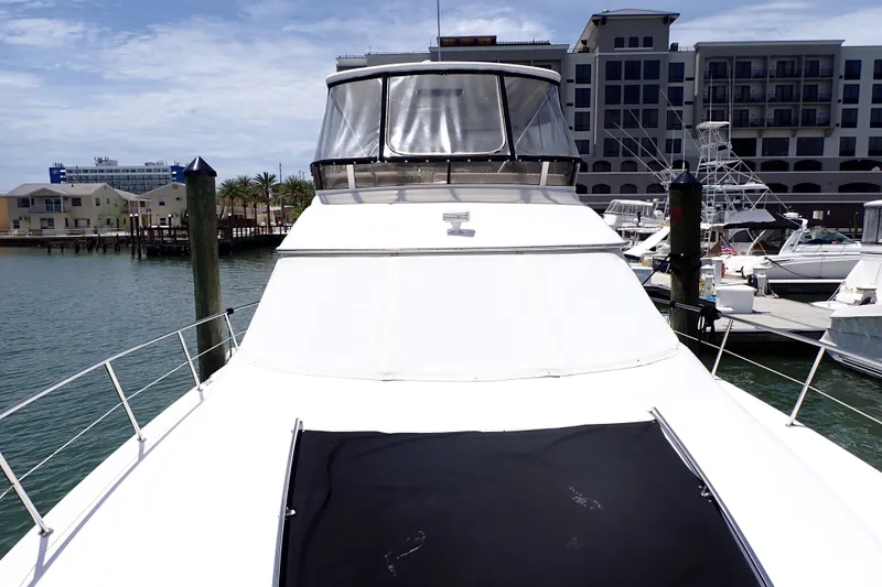 Slide: The Image of 1998 Sea Ray 480 Sedan Bridge yacht docked at marina, featuring sleek design and spacious deck. - 5