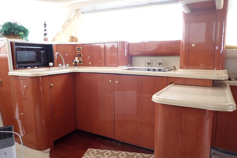 Slide: The Image of Luxurious kitchen interior of 1998 Sea Ray 480 Sedan Bridge yacht with wood cabinetry. - 16