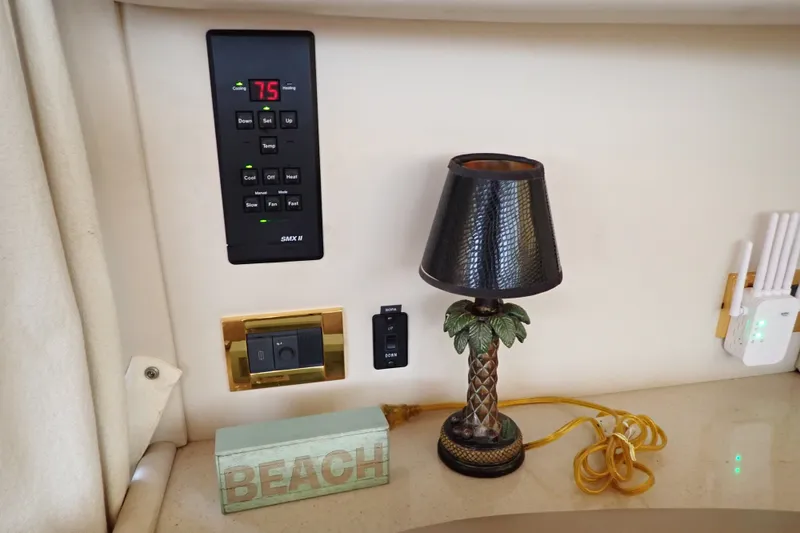 Slide: The Image of Interior of 1998 Sea Ray 480 Sedan Bridge with lamp, thermostat, and beach decor. - 130