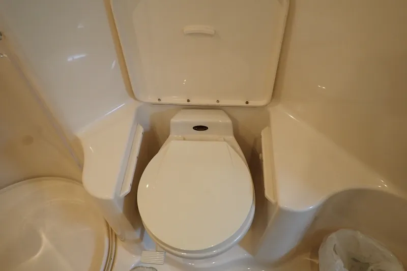 Slide: The Image of 1998 Sea Ray 480 Sedan Bridge bathroom with a compact marine toilet. - 182