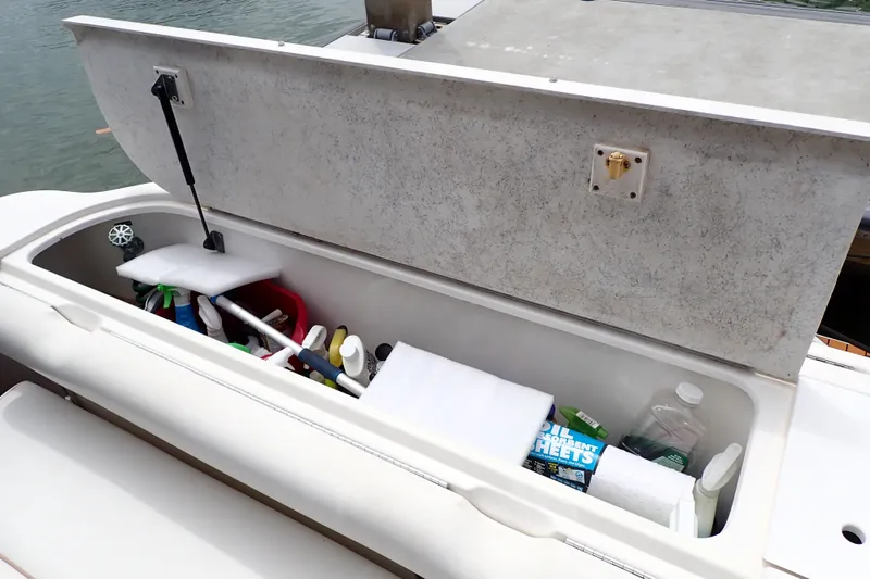 Slide: The Image of Storage compartment on a 1998 Sea Ray 480 Sedan Bridge, filled with cleaning supplies. - 81