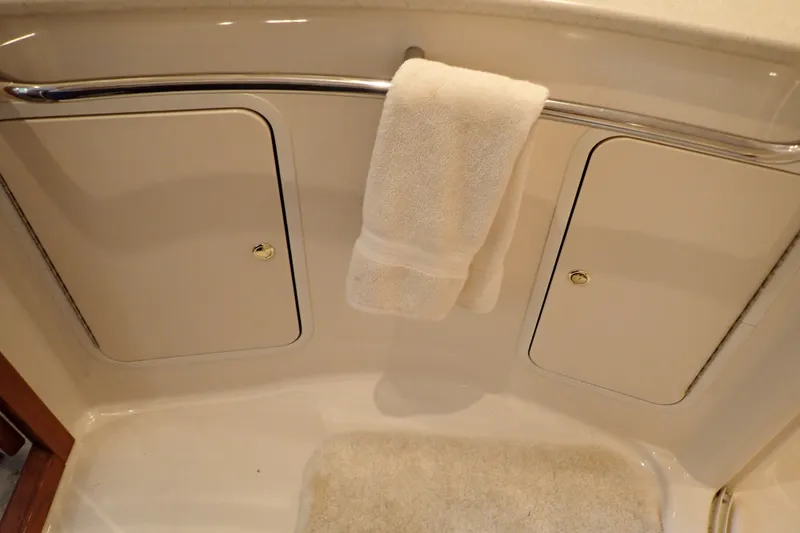 Slide: The Image of 1998 Sea Ray 480 Sedan Bridge bathroom with towel rack and storage compartments. - 184