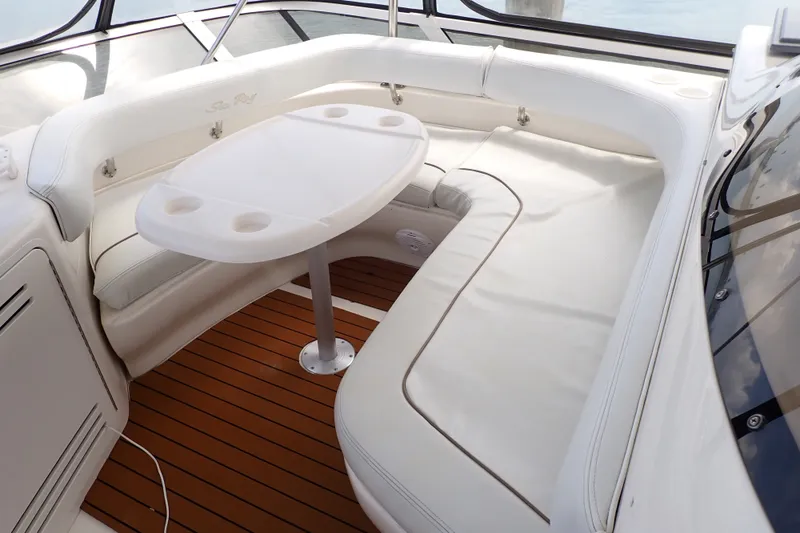 Slide: The Image of 1998 Sea Ray 480 Sedan Bridge interior with white seating and table on teak flooring. - 57
