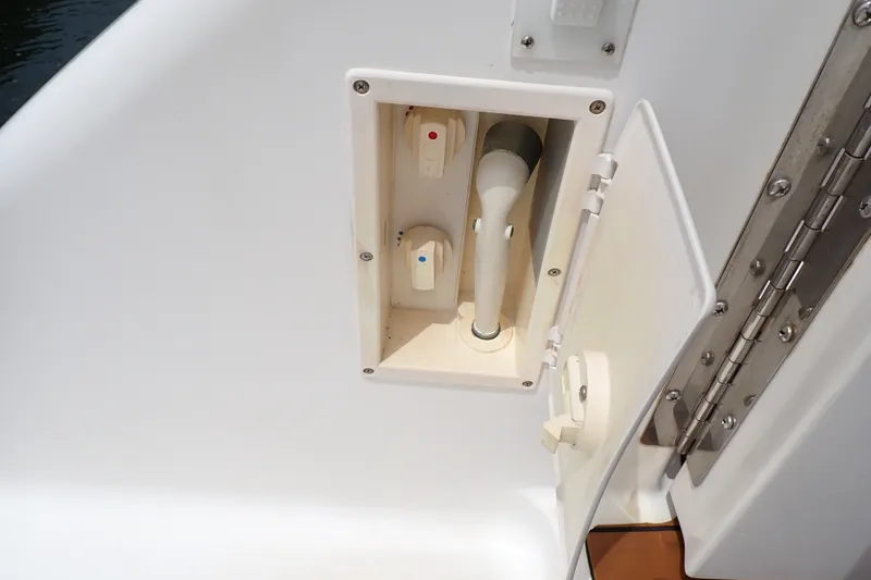 Slide: The Image of 1998 Sea Ray 480 Sedan Bridge shower compartment with controls and hose. - 84