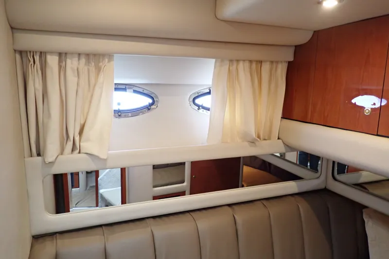 Slide: The Image of Interior cabin of 1998 Sea Ray 480 Sedan Bridge with porthole windows and curtains. - 145
