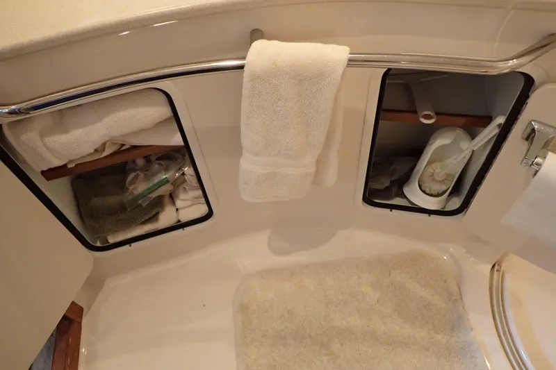 Slide: The Image of Bathroom storage on 1998 Sea Ray 480 Sedan Bridge yacht with towels and cleaning supplies. - 185