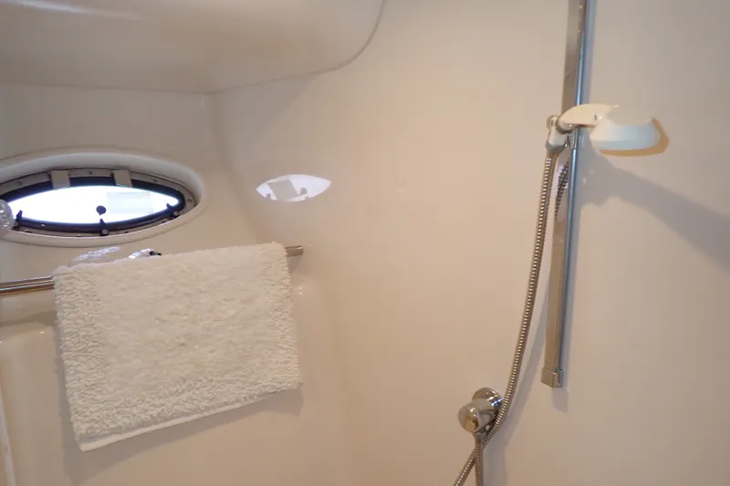 Slide: The Image of Shower area in 1998 Sea Ray 480 Sedan Bridge yacht with towel and porthole. - 163